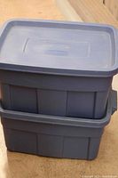 Stacked two large blue Rubbermaid Roughneck totes with lids, showing size and shape.