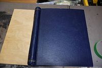 Closed blue vintage stamp album with textured surface and mild wear on edges.