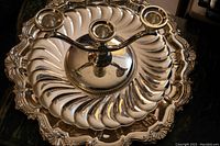 Birks Regency silver plate tray with detailed floral and scalloped border, holding the three-arm candle stand with candles placed on top, and swirl dish underneath.