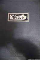 Blue stock album labeled 'ROMANIA STAMPS' on cover, indicating the theme of the collection inside.