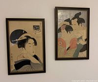 Photo showing both framed Asian-style prints hanging on a white wall; the prints measure approximately 16x11 inches.