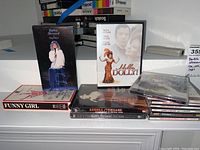Displaying entire lot including Funny Girl VHS, Barbra Streisand One Voice VHS, Dolly Parton DVD, Barbra Streisand Greatest Hits CD, plus multiple assorted CDs and tapes