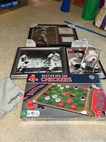 View of all items including checkers game, framed photos, Ted Williams card in display case, and a magazine on carpeted floor