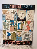 Full view of the framed 'The Yiddish Lesson' poster showing colorful illustrations of Yiddish terms with cartoon characters.