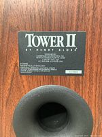 Rear label of one speaker showing Tower II by Henry Kloss badge, impedance and shielding info.