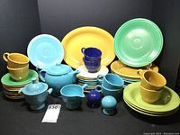 Full set of assorted Fiesta dinnerware pieces with plates, bowls, cups, and accessories in various colors arranged together.