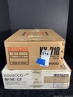 Stacked original boxes: Kenwood KX-710 cassette deck box atop Kenwood Basic C2 amplifier box