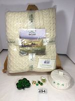 Full lot visible including wool throw in packaging, trinket box, glass shamrock paperweight, acrylic four leaf clover, and costume jewelry pieces