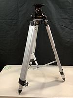 Full view of the Meade Deluxe Field Tripod standing upright on a table with legs extended.
