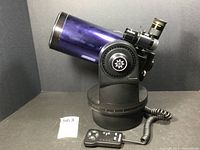 Telescope on fork mount with coiled-cable hand controller in front