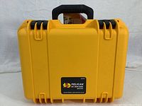 Front view of the bright yellow Pelican Storm Case iM2100 showing label and handle.