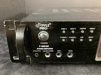 Close-up of left front panel showing power button, input jacks for iPod/MP3, headphones, MIC1 and MIC2, and tuning/navigation buttons.