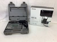 Sony receiver in open grey carrying case alongside boxed Denon dock