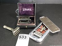 Set showing vintage Gillette all metal razor, Twinplex blade sharpener in box and Rolls Razor strop in metal case with leather strap inside.