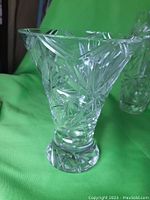 Crystal vase with wide flared rim and sharp, detailed cut pattern taking a floral star shape