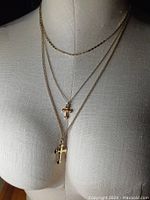 Image of the triple strand cross necklace on a mannequin bust showing three chains, two with cross pendants.