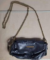 Front and top views of black vegan leather purse with gold chain shoulder strap and clutch chain by Matt & Nat.