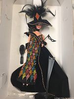 Masquerade Ball Barbie doll with feathered hat and multicolored sequin dress displayed in original box with brush and mask accessory visible.