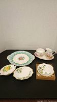 Photo of full set including sugar, creamer, several small dishes, and serving plate.