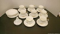 Full view of the set showing 6 teacups each paired with 6 saucers, 3 side plates stacked, and a covered side dish.