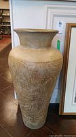 Full view of the tall vase showing its overall shape, color, and top opening.