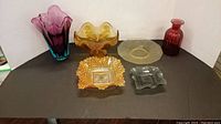 Overview of all six items: 2 vases and 4 dishes in varied colors and shapes on black surface against white background.