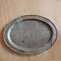 Top view of brass oval tray showing overall design and wear areas