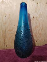 Front view of teal blue vintage mid-century art glass vase showing textured bubble pattern and tapered neck.