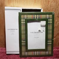 Photo of the Liz Claiborne Home 4x6 picture frame in its original box showing the front with plaid pattern and green border.