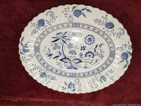 Oval serving plate with Blue Nordic pattern by J & G Meakin on a red cloth background showing full plate front and pattern details.