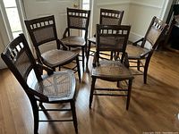Six chairs arranged in a circle on hardwood floor