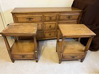 Two matching light wood side tables with single drawer and lower shelf, showing surface wear and scuff marks