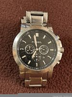 Front view of Fossil FS4311 men's wristwatch showing black dial with chronograph subdials and wear on metal bracelet.