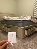 Side view of bed frame showing two drawers open and paneled headboard
