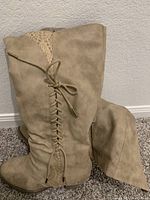 Single tan calf high boot showing lace-up detail on the back and suede-like material