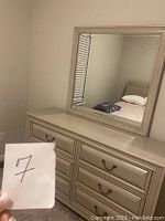 Front view of six-drawer dresser with matching rectangular mirror in metallic silver finish