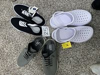 Photo showing three pairs of shoes: black and white lace-up canvas shoes, white slip-on clogs, and gray casual sneakers, all size 9.