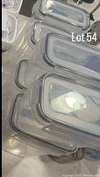Six rectangular plastic containers with clear snap-lock lids arranged in a stack on a surface.