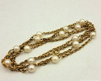 Full view of vintage gold fill chain pearl necklace laid out showing multiple pearls spaced on twisted rope chain.