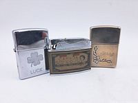 Photo of three lighters, two Zippo engraved and one with Canada label.