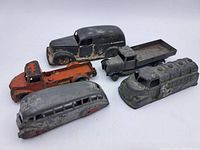 Front view of five vintage metal toy vehicles showing condition and details