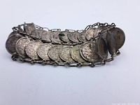 Image showing the entire bracelet laid out, displaying the connected coins and chain links