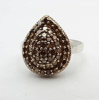 Front view of pear-shaped sterling silver ring with multiple small champagne diamonds clustered on top.