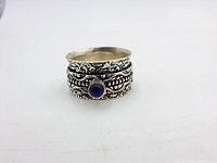 Sterling silver vintage spinner ring front view showing blue stone and floral engravings.