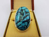 Top view of the sterling silver ring showing large oval turquoise stone with matrix pattern set in polished bezel.