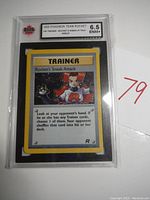 Front view of the 2000 Pokémon Team Rocket Trainer Rocket's Sneak Attack Holo card slabbed and graded 6.5 ENM+