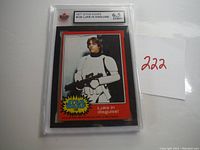 Photo showing the graded card encased in protective plastic with label reading '1977 Star Wars #125 Luke in Disguise' graded 6.5 by ENMI.