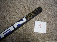 Close-up of stick shaft end with 'USA 97/98' painted in gold marker.