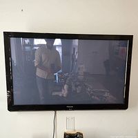 Panasonic Viera TC-P50X3 plasma HDTV mounted on wall, reflecting minimal background.