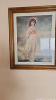 Full view of framed art print showing woman in white dress with red sash and headband.